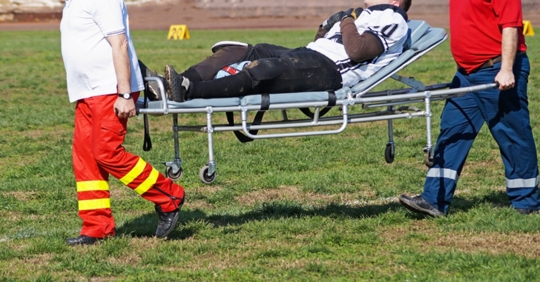 Paramedics carrying an athlete on a stretcher