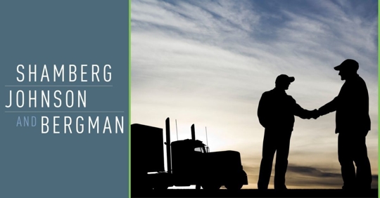 Silhouetted truck drivers shaking hands