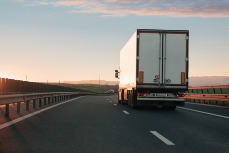 Rear view of semi-truck driving on two-lane highway